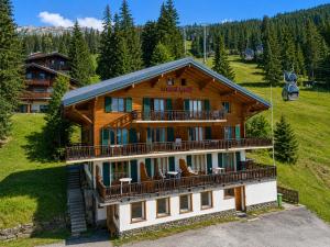 a large log building on a hill with trees at Mont Gele Hotel in Verbier