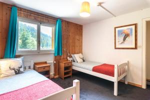 a bedroom with two beds and a window at Mont Gele Hotel in Verbier