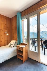 a bedroom with a bed and a balcony at Mont Gele Hotel in Verbier