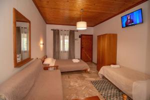 a bedroom with two beds and a tv on the wall at Kastraki Villas in Nafplio