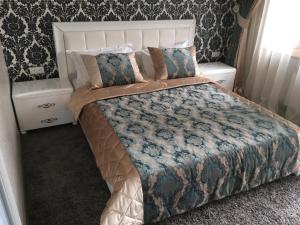 1 dormitorio con 1 cama grande y 2 mesitas de noche en Apartments on Bunina 28 en Odesa