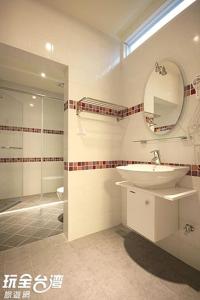 a bathroom with a sink and a mirror and a shower at 歐拉民宿 l 大空間包棟 l 親子溜滑梯 l 專業音響 in Taitung City +49 photos