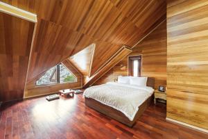 a bedroom with a bed in a room with wooden walls at AT House Dalat - The Pine Concept in Da Lat +29 photos