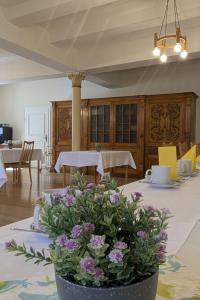 a dining room with a table with purple flowers on it at Ursulinenkloster in Duderstadt