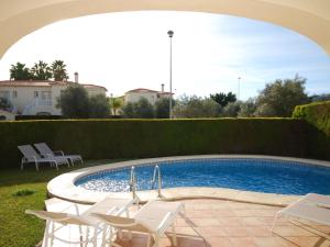 una piscina con sillas blancas y una piscina en Charming Villa in Oliva with Private Swimming Pool, en Oliva