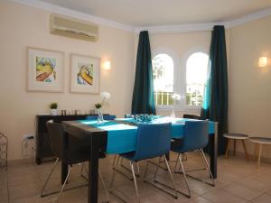 comedor con mesa azul y sillas en Charming Villa in Oliva with Private Swimming Pool, en Oliva