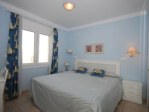 Un dormitorio con una cama con paredes azules y una ventana en Charming Villa in Oliva with Private Swimming Pool, en Oliva