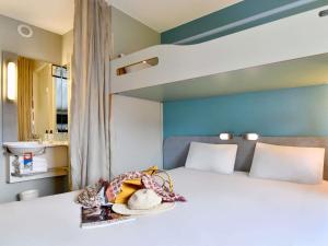 a bedroom with a white bed with a bunk bed at ibis budget Cholet Centre in Cholet