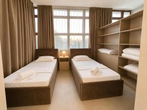two beds in a small room with a window at Grand Sky Hotel in Almaty +17 photos