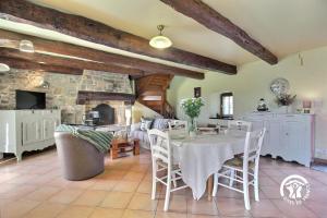 a dining room with a table and a stone fireplace at Des puits in Locoal-Mendon