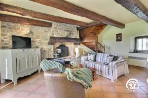 a living room with a couch and a stone fireplace at Des puits in Locoal-Mendon +28 photos