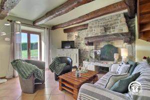 a living room with couches and a stone fireplace at Des puits in Locoal-Mendon