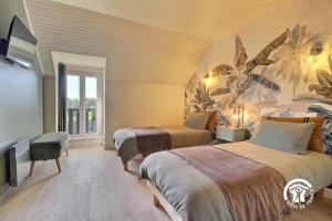 a bedroom with two beds and a window at Des puits in Locoal-Mendon
