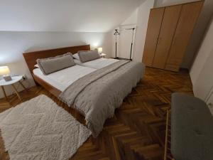 a bedroom with a large bed and a wooden floor at Apartmani Zinda in Sukošan