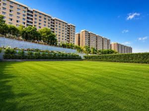 a large grass field in front of a building at Pride Plaza Indore in Indore