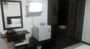 a bathroom with a television and a small refrigerator at Mark Four Place Hotel in Phrae