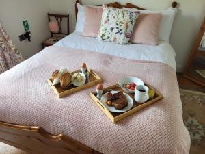 two trays with breakfast foods on a bed at Mill Villa Pakefield in Pakefield