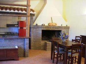 a kitchen and dining room with a fireplace and a table at Agriturismo Radicata in Capalbio