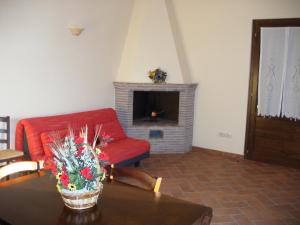 a living room with a red couch and a fireplace at Agriturismo Radicata in Capalbio