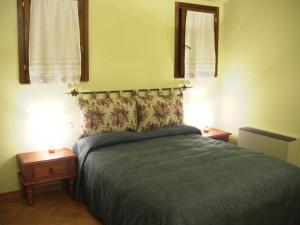 a bedroom with a bed with two nightstands and two lamps at Agriturismo Radicata in Capalbio