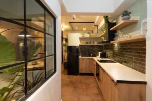 a kitchen with wooden cabinets and a black refrigerator at Cotto Apartment in Agios Nikolaos