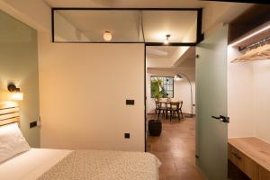 a bedroom with a bed and a dining room at Cotto Apartment in Agios Nikolaos