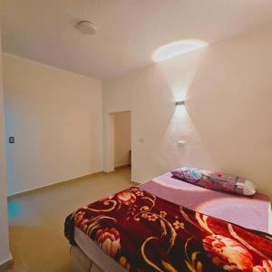 a bedroom with a bed with a red blanket on it at Moon Dune Camp in Nuweiba