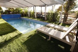 a swimming pool with a bench in the grass at Iinfinity home in Had Nes +30 photos