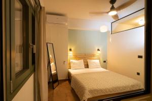 a small bedroom with a bed and a window at Cotto Apartment in Agios Nikolaos