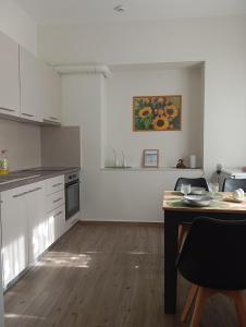 a white kitchen with a table and a counter top at Anatoli's house in Kastoria