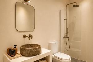 a bathroom with a sink and a toilet and a mirror at Lanu Apartments in Argostoli