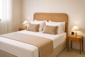 a bedroom with a large white bed with two lamps at Lanu Apartments in Argostoli