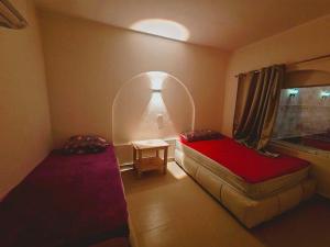 a small room with two beds and a window at Moon Dune Camp in Nuweiba +8 photos