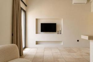a living room with a television on a wall at Lanu Apartments in Argostoli