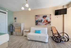 a living room with a couch and a tv at Kalokairi Boutique Residence in Skopelos Town