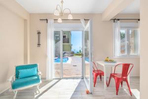 a dining room with red chairs and a white table at Kalokairi Boutique Residence in Skopelos Town