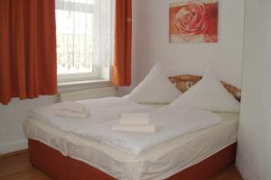 a white bed with towels on it in a room at Pension Am Renner in Dresden