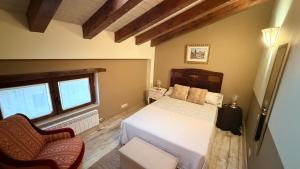 a bedroom with a bed and two windows at Los Quejigares in Terradillos de Sedano