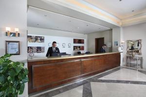 two men standing at a reception desk in a lobby at Mandarin Resort & Spa in Bodrum City