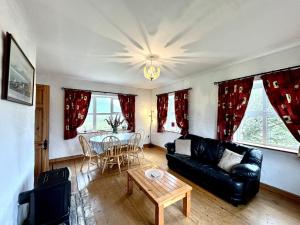a living room with a black leather couch and a table at Twelve Bens Lodge in Recess +16 photos