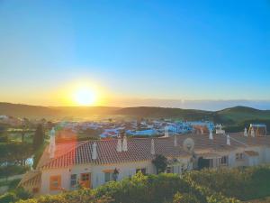 a view of a house with the sunset in the background at Villa Sunrise by MOJE Holiday in Budens