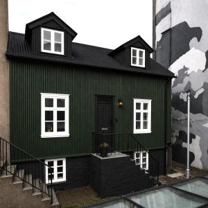 a green house with a black roof at Grettir Guesthouse Downtown Charm in Reykjavík