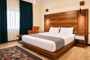 a bedroom with a large bed and a chair at Diamond Motel in Baghdād