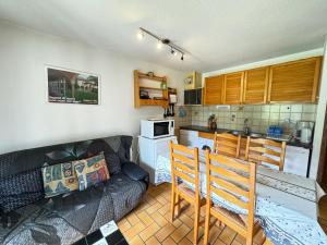 a living room with a couch and a kitchen at Les Crêtes studio divisible by Mountain Collection Immobilier in Le Monêtier-les-Bains