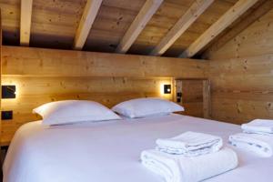 a bedroom with a bed with white towels on it at Cozy Chalet with Terrace Peaceful Nature Views in Bluffy
