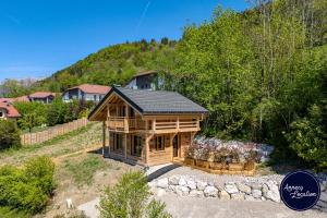 a large log cabin with a black roof at Cozy Chalet with Terrace Peaceful Nature Views in Bluffy