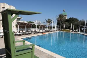 a large swimming pool with chairs and a building at Dan Panorama Haifa Hotel in Haifa