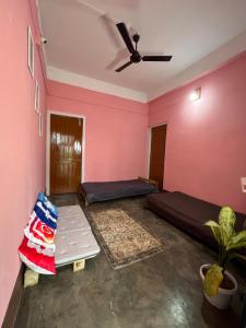 a room with pink walls and a ceiling at The Backpackers Hostel in Guwahati