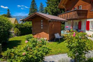 a backyard with a wooden house with a gazebo at Gemütliches Gartenhüttli mit Alpenblick in Meiringen