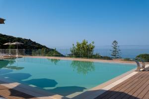 a large blue swimming pool with a chair next to it at Hotel Baia Imperiale in Campo nell'Elba